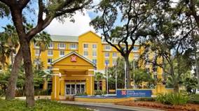 A yellow building with trees and a sign

Description automatically generated